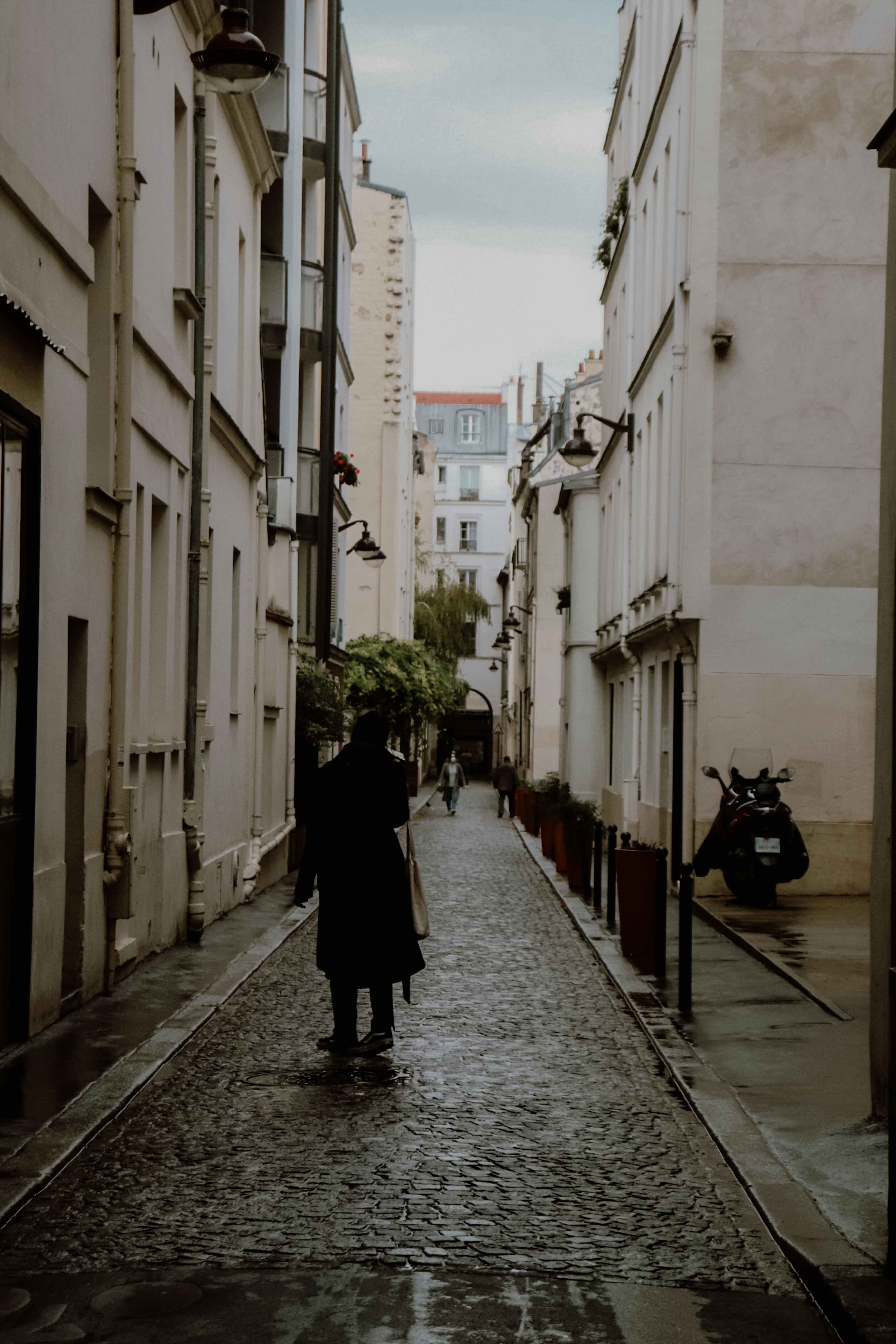 person in black coat walking on street during daytime